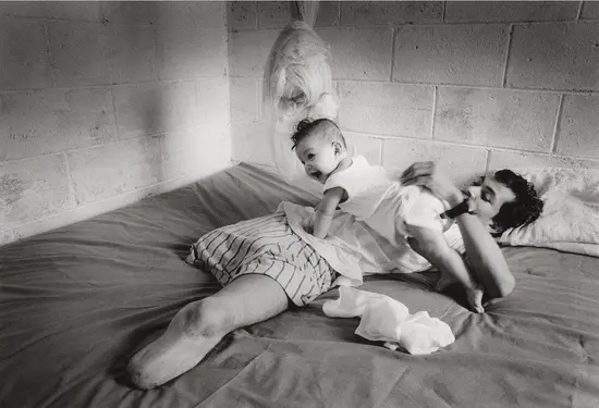 Manuel Orellana, mutilado por una mina, con su hija. Apopa (El Salvador), 8 de 1997